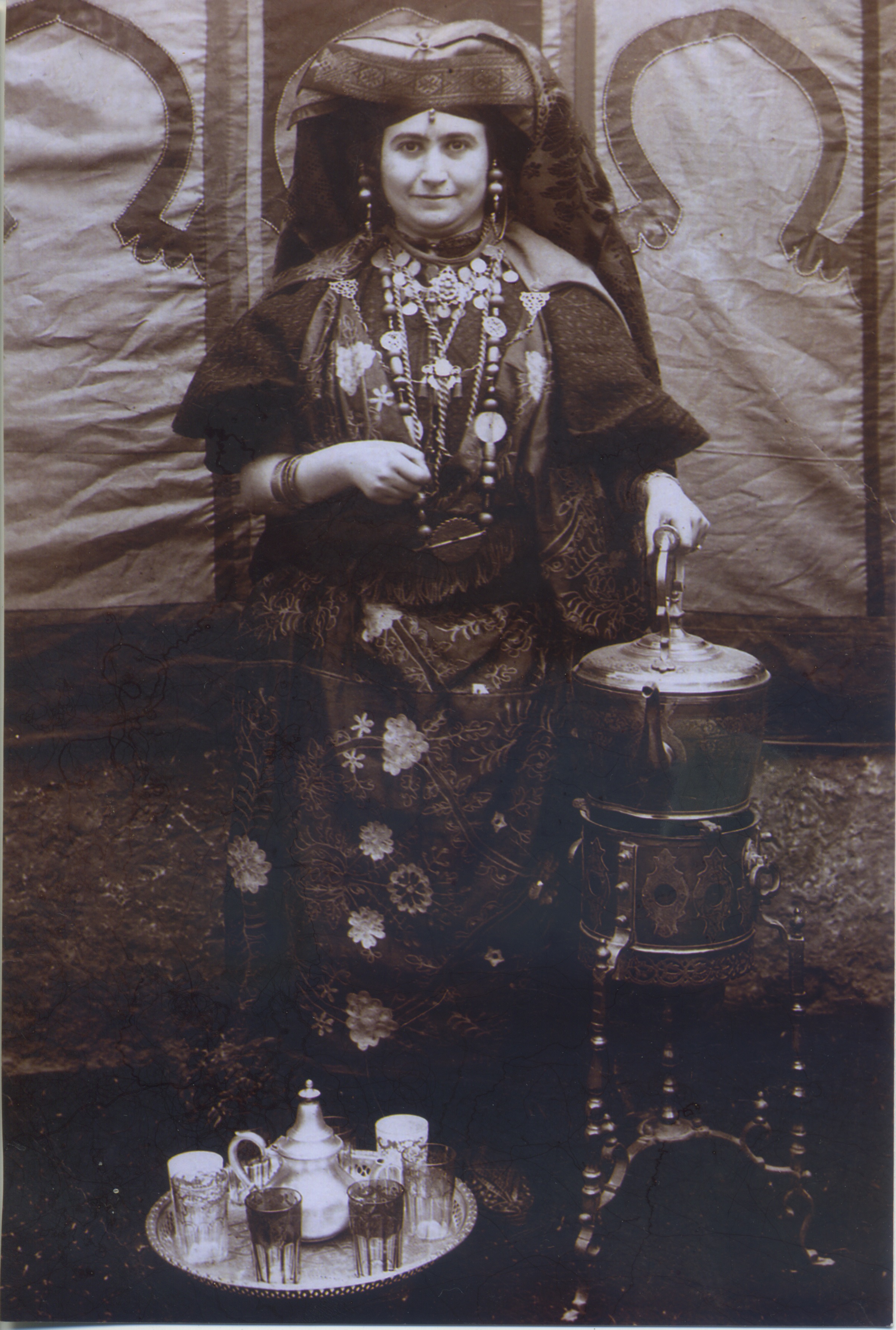 Women in traditional dress with a large urn